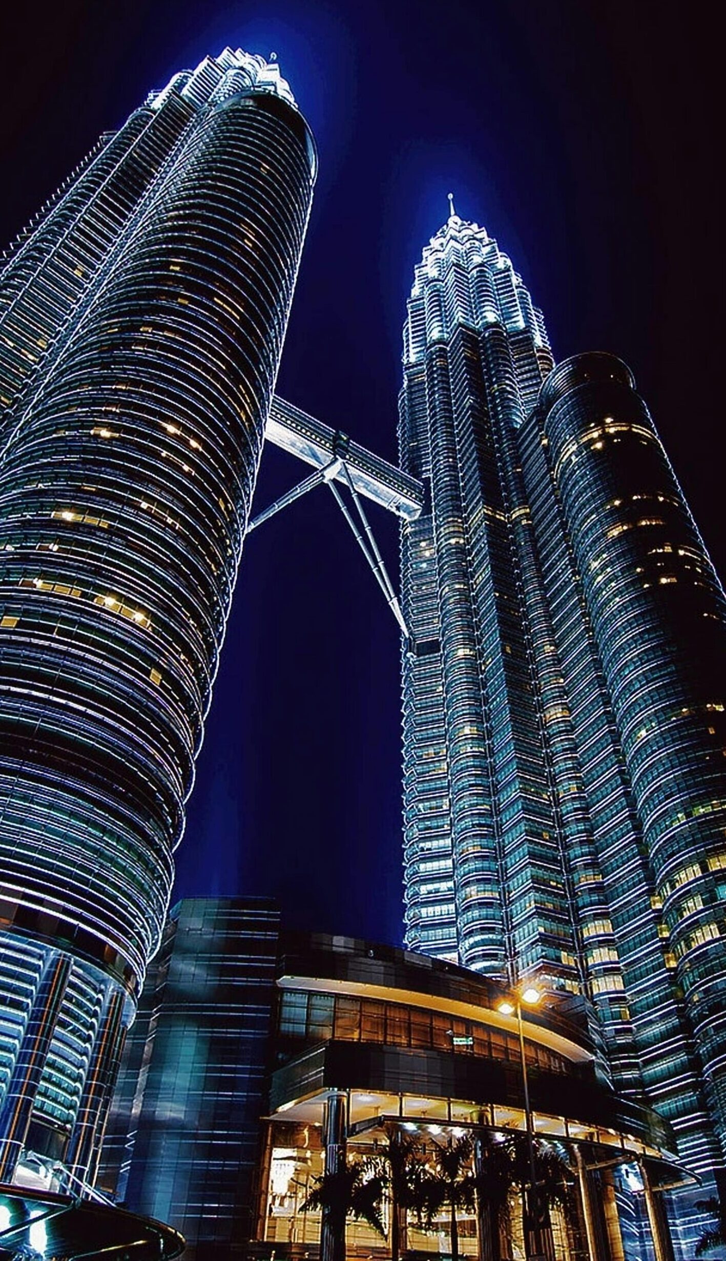 Stunning nighttime view of the illuminated Petronas Towers in Kuala Lumpur, Malaysia.